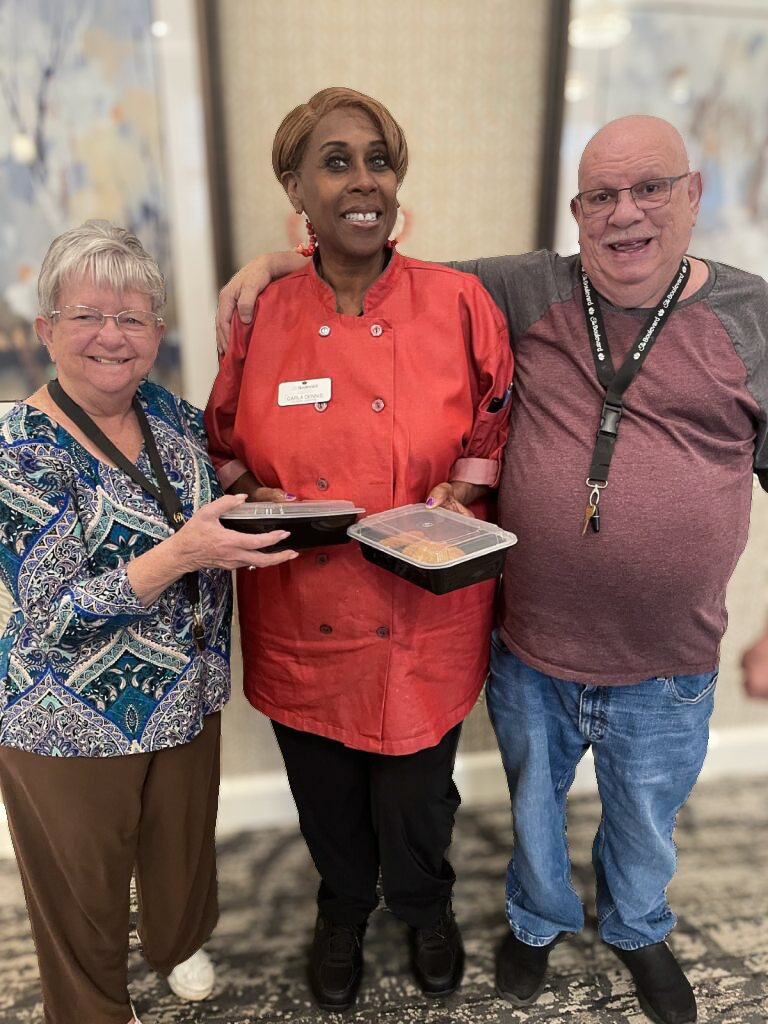 Team member and senior residents smile together at The Boulevard Senior Living of St. Peters.