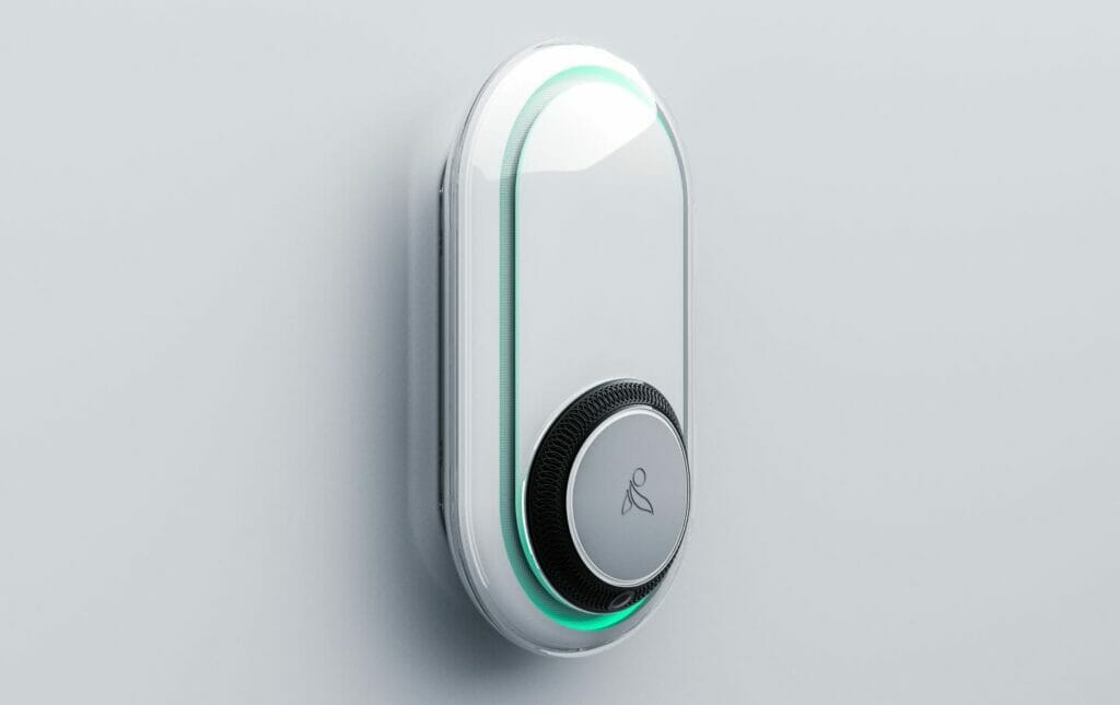 Close-up of the Inspiren AUGi device mounted on a wall, featuring a sleek white design with a glowing green light indicator used for wellness monitoring and fall detection.