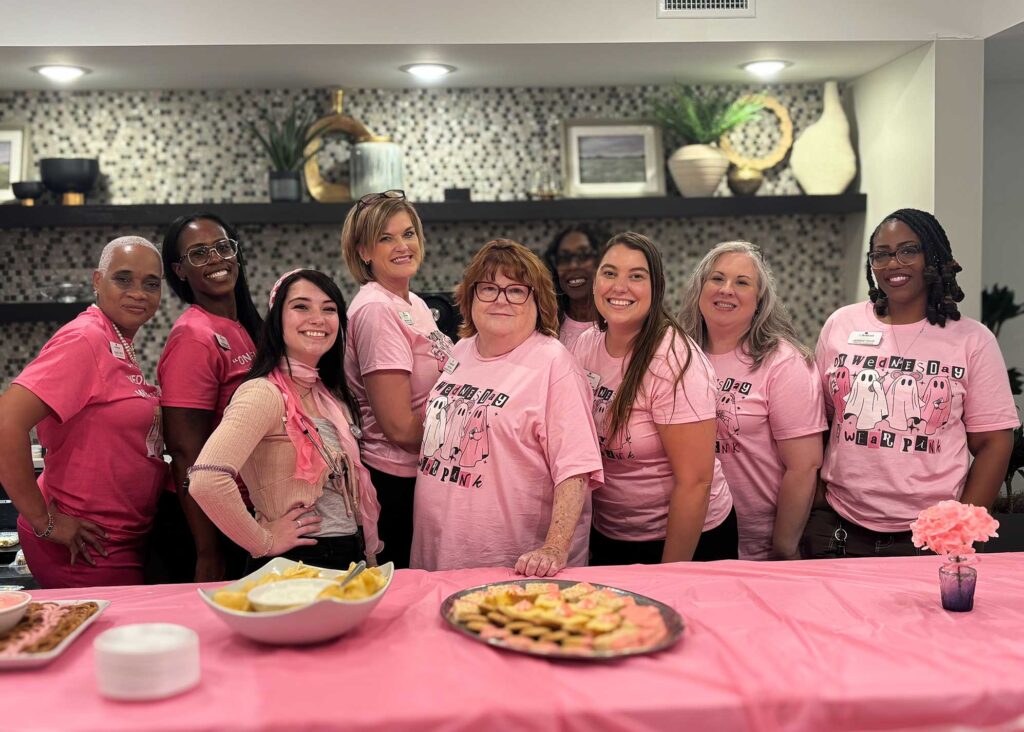 Group photo of team members all wearing pink during an event.