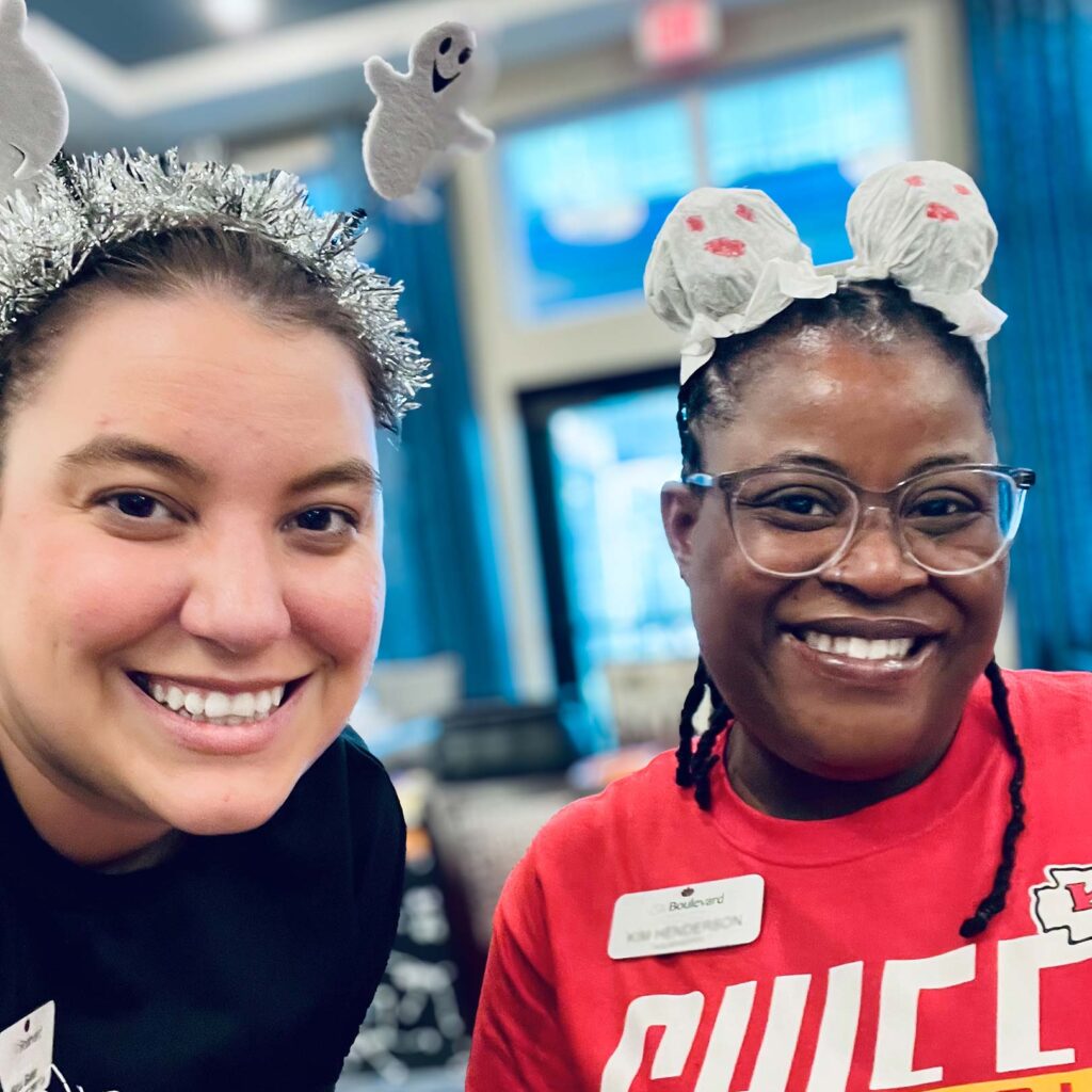 Two young women smiling while wearing fun antennae headbands.