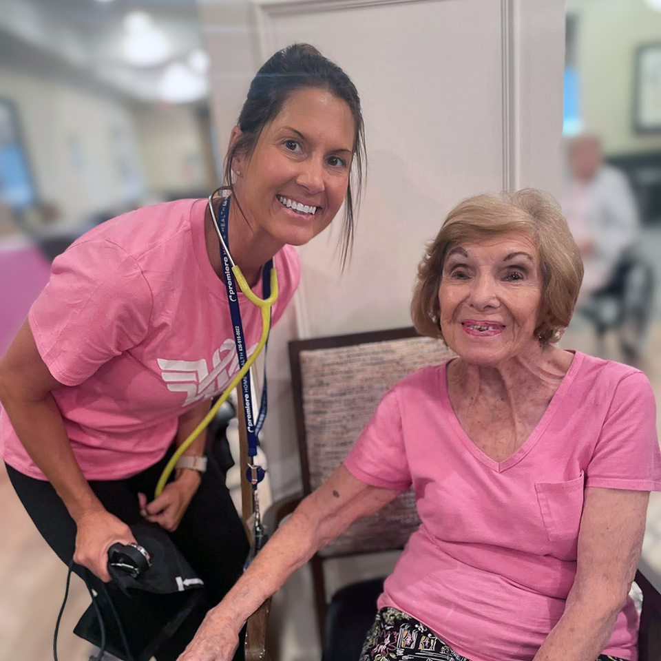 A team member and senior woman smile during a wellness event at The Boulevard Senior Living of Saint Peters.